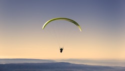 Yellow paragliding on pastel  sky