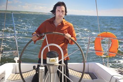 Young  skipper driving sailboat / Captain of the yacht