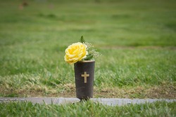Yellow flowers set at graveside in memorial cemetery in California.