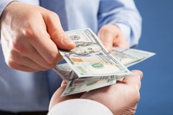 Human hands exchanging money on blue background, closeup shot