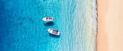 Seascape with boats near beach. Aerial view of floating boat on blue sea at sunny day. Top view from drone at beach and blue sea. Vacation and holidays