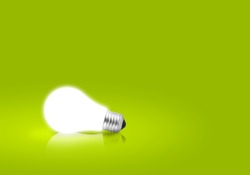 One glowing Light bulb on green background. Concept