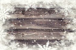 The brown wood texture with snow flakes over it. Winter background