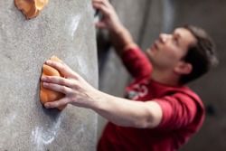 young caucasian man rock climbing indoors