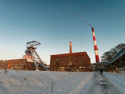 Buildings of a closed hard coal mine in Pszów, Poland. A mine shaft, an industrial building and tall brick chimneys