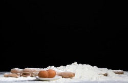 eggs, white wheat flour and other ingredients on the Board, in the kitchen while cooking food