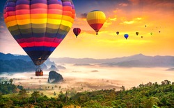 Aerial view from colorful hot air balloons flying over with the mist at Phu Langka national park in sunrise time,  Phayao province in Thailand.