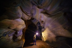 Woman with Torch lamp exploring huge ancient fortress cave