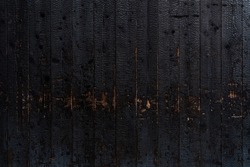 Burnt wooden plank surface after a fire. Details with patterned wood surface texture was charred. Footprint of Fire on Its Surface .Background Texture for use