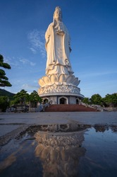White Lady Buddha at Linh Ung Pagoda in Danang (Da Nang), Vietnam. Majestic white Buddha statue on blue sky background. Giant white standing lady Buddha statue in Chùa Linh Ứng Buddhist temple