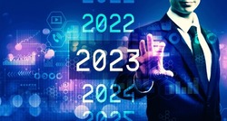 2023 New Year concept with businessman on blurred blue light background