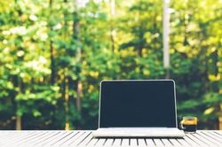 Laptop computer outside with a forest background