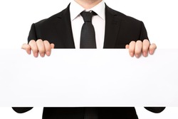 Isolated businessman in a suit holding a large white sheet of paper or banner