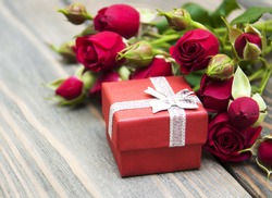 Red roses  and gift box on a wooden background