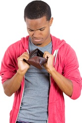 Closeup portrait of stressed, upset, sad, unhappy young man standing with, looking into empty wallet, isolated against white background. Financial difficulties, bad economy concept. Negative emotion
