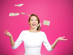 Closeup portrait super excited, laughing young woman who just won lots of money, trying to catch, throw dollar bills in air, isolated pink background. Positive emotion, facial expression, feelings.