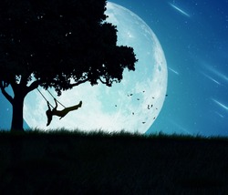Silhouette of happy young woman on a swing of a tree isolated on beautiful background of moon, earth, night skyline, falling stars. Body vitality, human spirit well being, freedom, happiness concept