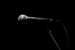 Black classic microphone on a black dark background. Music and concert concept.