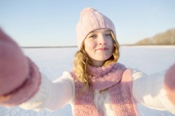 Pretty young female tourist takes selfie in winter