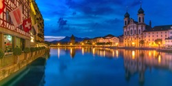 Jesuit Church, Water Tower, Wasserturm, and traditional frescoed building along the river Reuss at night in Old Town of Lucerne, Switzerland