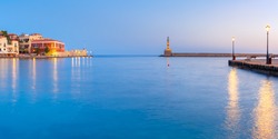 Picturesque panoramic view of old harbour with Lighthouse of Chania during twilight blue hour, Crete, Greece