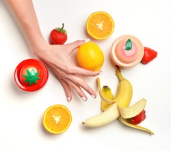Skin care concept. Hands with fruits orange lemon banana peach and strawberry