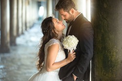 Passionate stare and kiss romantic attractive lovers bride and handsome groom couple 