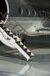 Stairs and door private jet in hangar ready to fly- stock photo