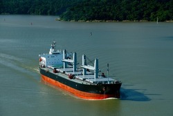 Aerial view of  grain cargo ship in transit crossing Gatun lake in the Panama Canal. - stock photo