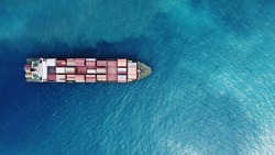 a container ship loaded with containers and cargo on open ocean waters aerial  