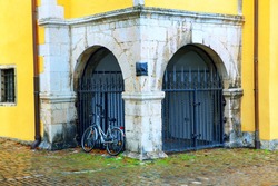 Bicycle in the old town . Ecological type of transport . Bike near black gates