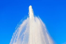 Fountain splashing water against blue sky . Spurt of water rising from a fountain 
