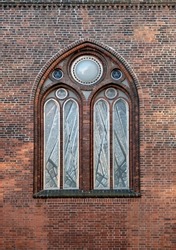 Beautiful large arched window in the brick wall of the Dome Cathedral in Riga, Latvia, Europe.