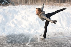 young Figure skating woman at the frozen lake in the winter