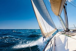 White sailing boat at open sea in sunshine
