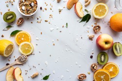 Healthy food vegan breakfast nutrition concept, fresh summer fruits nuts granola seeds on white background, organic super food on table, detox diet for health care, top close up view, copy space