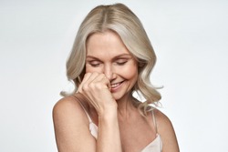 Happy smiling pretty shy 50s middle aged woman laughing, cheerful mature lady touching healthy soft face skin. Anti age healthy skincare treatment and cosmetic ads. Face close up view portrait.