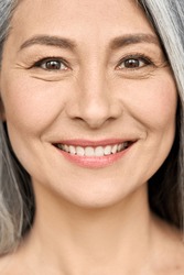 Happy smiling senior older middle aged Asian woman with grey hair and radiant face with perfect skin. Advertising of radiant foundation skincare and makeup for natural glow and healthy skin.