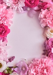 Many different pink flower mix frame floral background with white blank clear copy space. Blossom composition flatlay with copyspace, postcard design, spring greeting card template. Top view, flat