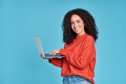 Young happy latin woman using laptop device isolated on blue background. Smiling female model user holding computer presenting advertising job search or shopping website, online services concept.