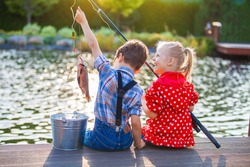 Little boy and girl fishing in a river. Sitting on a wood pontoon