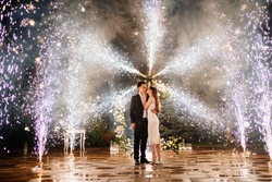 happy bride and groom are standing in the hallway of the fountains of the fireworks. beautiful end to the wedding day celebration.