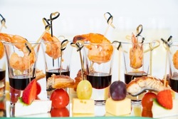 canapes of cheese with fruit, fish with cherry tomatoes and shrimp with sauce in a glass. interesting serving of snacks for the buffet. Catering. restaurant business.organization of lunches and events