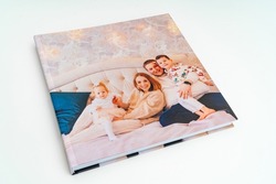 cover of book with photos of big family at home on a white background. Photobook is gift. professional photographer and designer. printing of photos and journals in photo laboratory