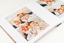 a book with photos of family at home on a white background. Photobook is gift. professional photographer and designer. printing of photos and journals in photo laboratory