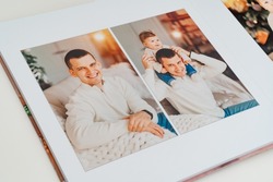 Photobook with photos of family photo shoot. beautiful, happy family with child in photo studio. services of professional photographer and designer. printed materials in printing, photo laboratory.