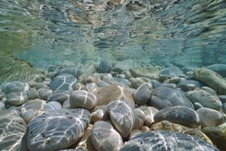 Pebbles and rocks below water surface underwater in the Mediterranean sea, Valencia, Spain