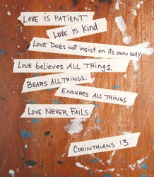 Corinthians 13 written on masking tape stuck to an old board