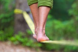 Slacklining is a practice in balance that typically uses nylon or polyester webbing tensioned between two anchor points.