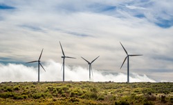 Four big wind generators in the mountain field over the clouds. Madeira island, ER105 road, Portugal.